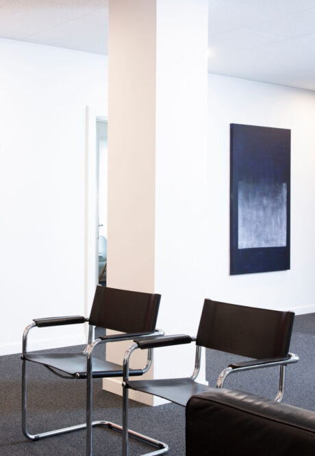 Centre de formation Medipsy, salle d’attente avec fauteuils noirs et tableau abstrait